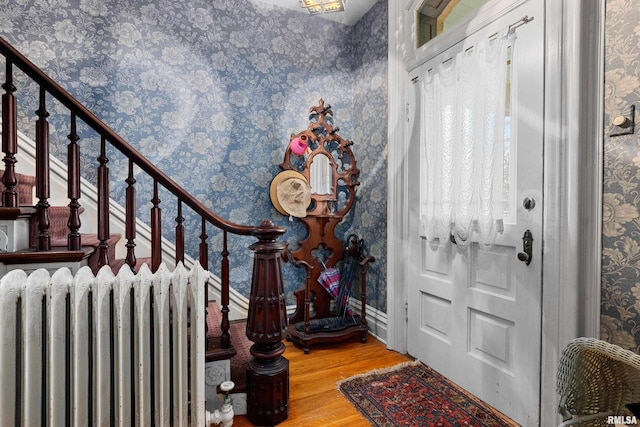 foyer entrance featuring radiator and hardwood / wood-style floors