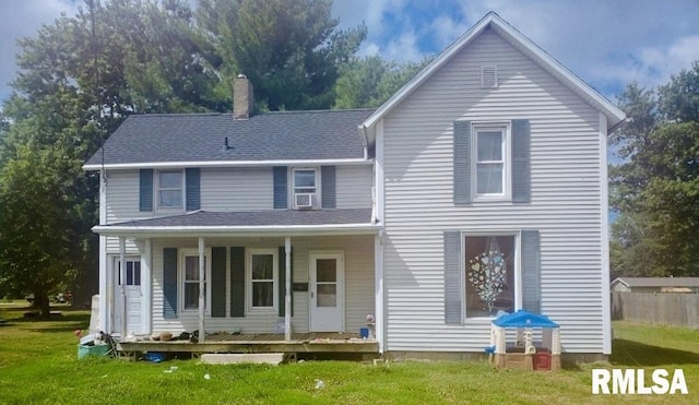 view of front of property with cooling unit, a front yard, and covered porch