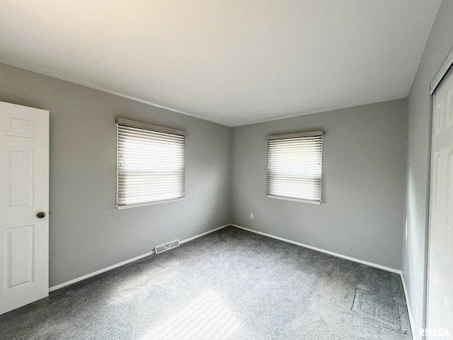 unfurnished room featuring dark carpet