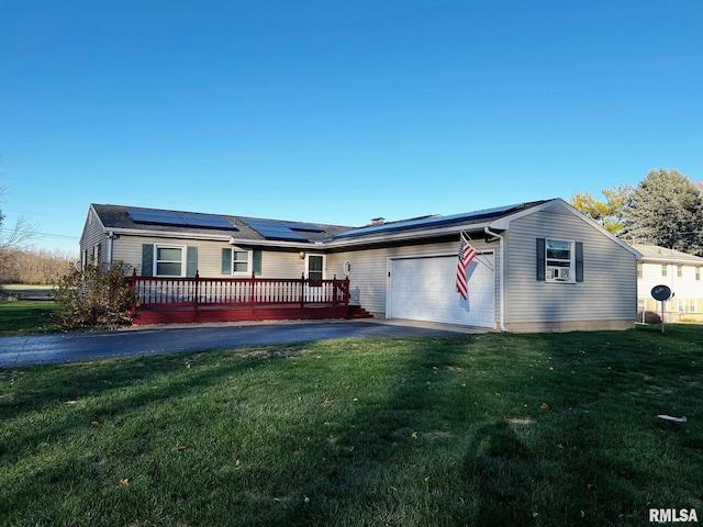 single story home with solar panels, a garage, a wooden deck, and a front lawn