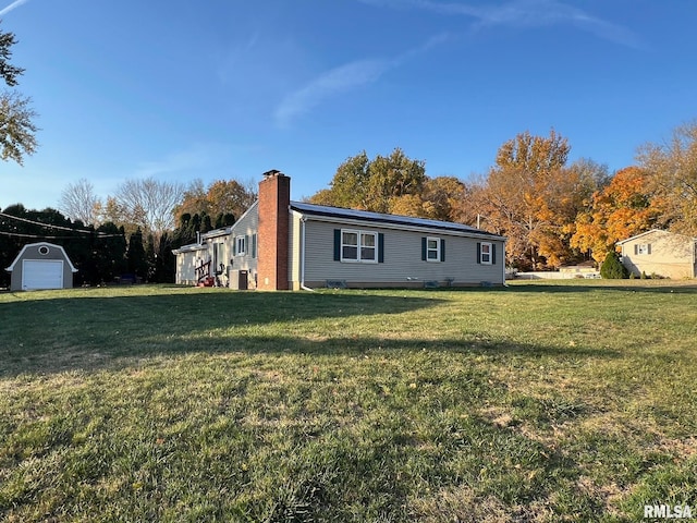 view of front of house with an outbuilding and a front lawn