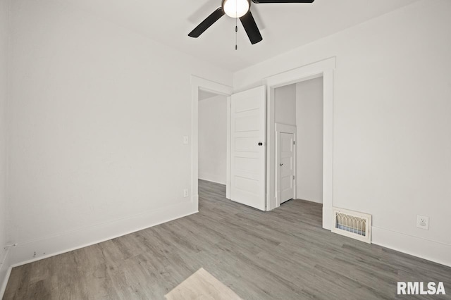 empty room with hardwood / wood-style floors and ceiling fan