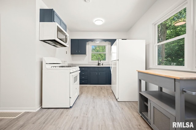 kitchen featuring light hardwood / wood-style floors and white appliances