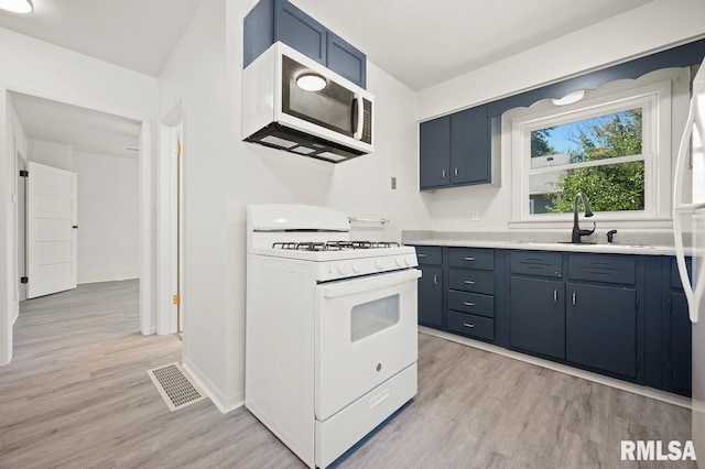 kitchen with blue cabinetry, sink, light hardwood / wood-style floors, and white gas range