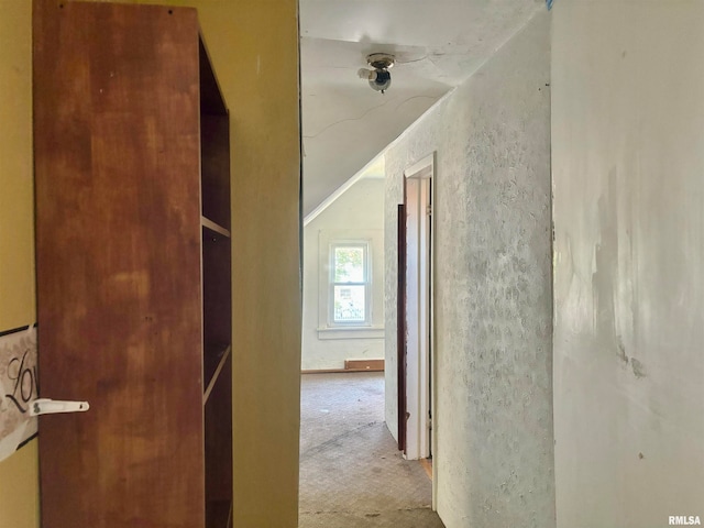 hallway with light carpet and lofted ceiling