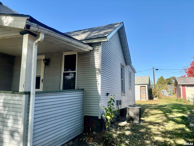 view of side of home with a yard and central AC unit