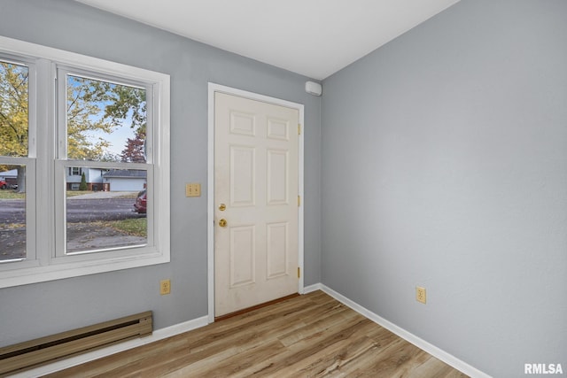 foyer with light hardwood / wood-style flooring and a baseboard heating unit