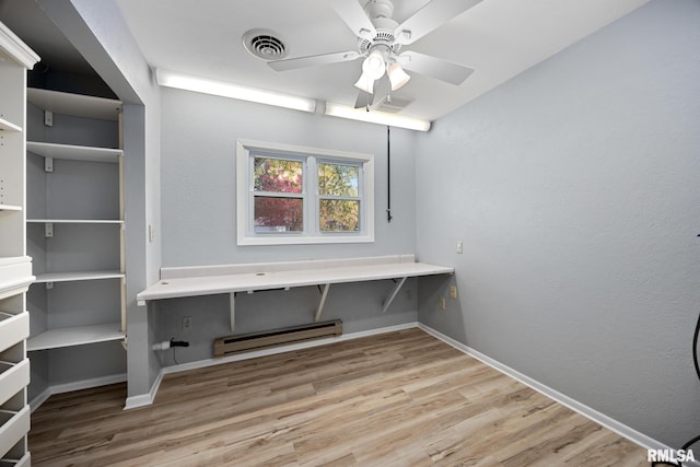 clothes washing area with light hardwood / wood-style flooring, a baseboard radiator, and ceiling fan