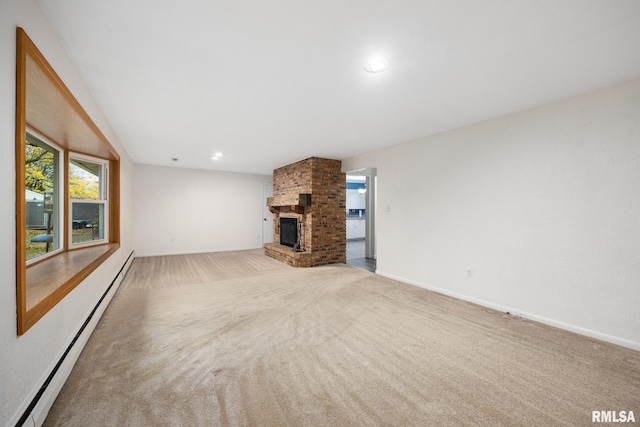 unfurnished living room with a brick fireplace, light carpet, and a baseboard heating unit