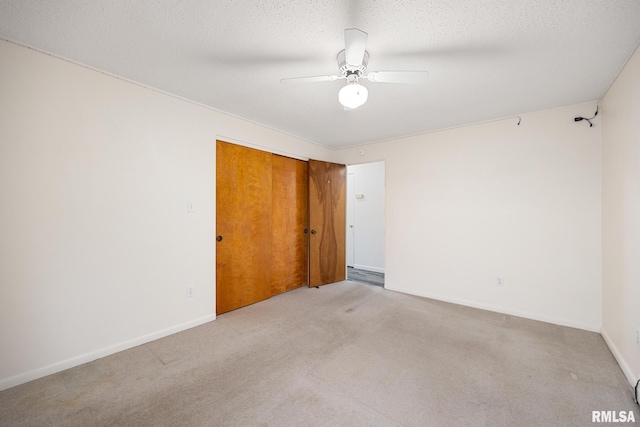 carpeted empty room with a textured ceiling and ceiling fan