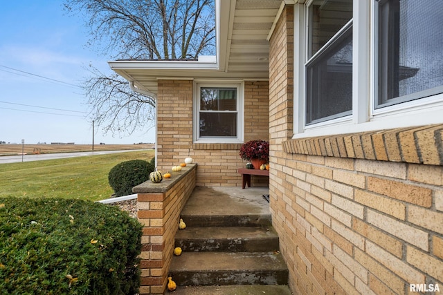 property entrance featuring a lawn