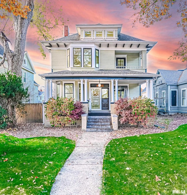 view of front of property with a porch and a yard