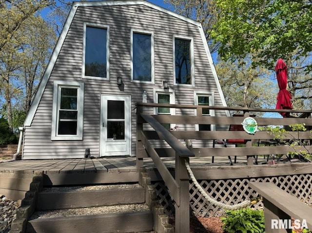 view of front of home featuring a deck and a gambrel roof