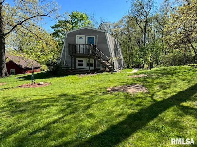 rear view of property with a yard, stairway, and a gambrel roof