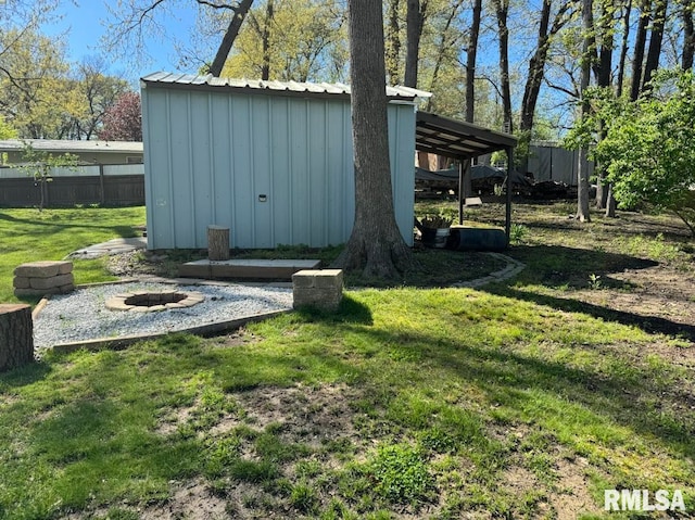 view of yard with an outdoor fire pit and a storage unit