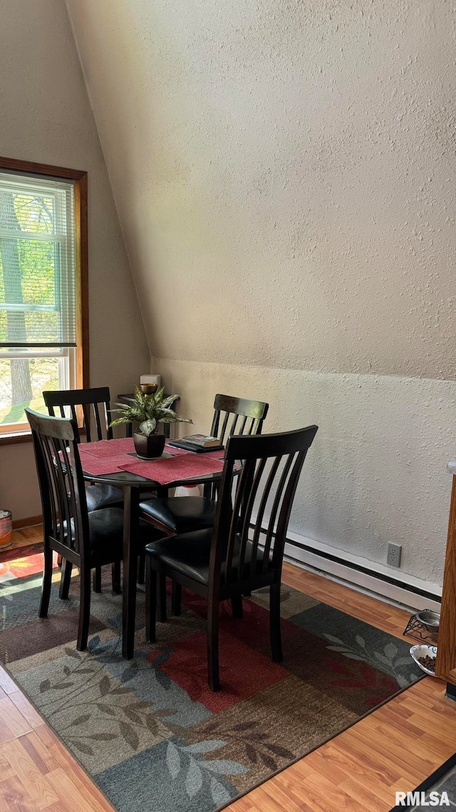 dining area with lofted ceiling and wood-type flooring