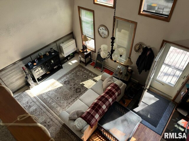 living room featuring heating unit, wood finished floors, and a healthy amount of sunlight