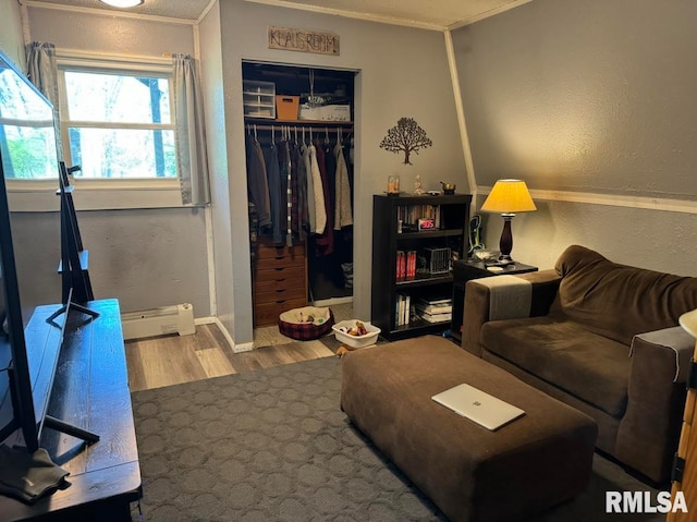 living room with baseboard heating, crown molding, and hardwood / wood-style flooring