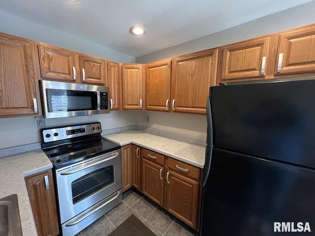 kitchen featuring brown cabinets, stainless steel appliances, and light countertops