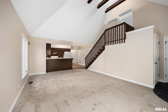 unfurnished living room featuring light carpet and high vaulted ceiling