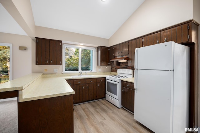 kitchen featuring white appliances, sink, light wood-type flooring, dark brown cabinets, and kitchen peninsula