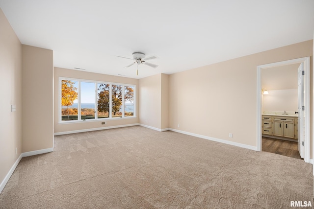 carpeted empty room with ceiling fan and sink