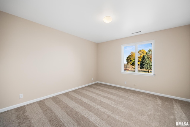 spare room featuring light colored carpet