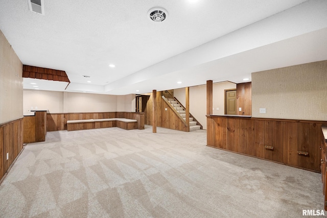 basement with light colored carpet and wooden walls