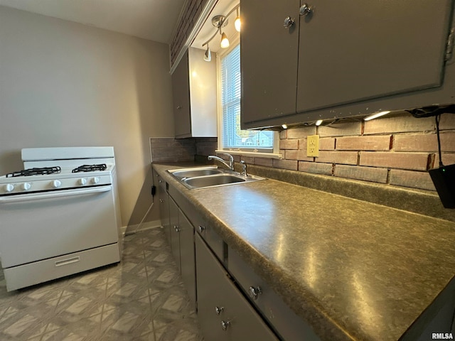 kitchen with sink, tasteful backsplash, white range with gas cooktop, and gray cabinetry