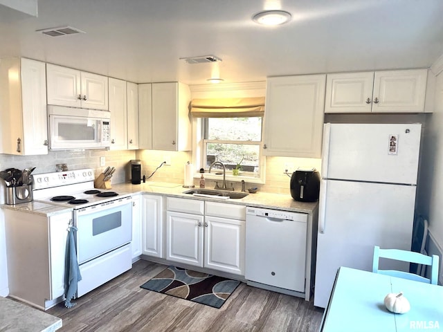 kitchen featuring white appliances, white cabinetry, sink, and wood-type flooring