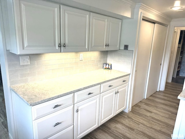 kitchen featuring white cabinets, light stone counters, and wood-type flooring