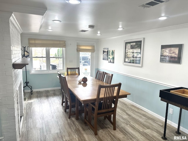 dining space featuring crown molding and hardwood / wood-style flooring