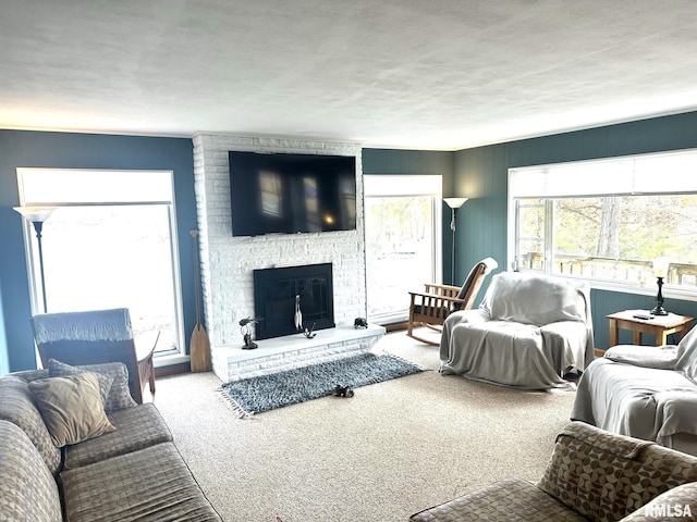 carpeted living room featuring a stone fireplace and a textured ceiling