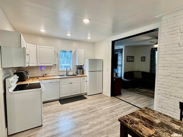 kitchen featuring decorative backsplash, white cabinetry, light hardwood / wood-style floors, sink, and white appliances