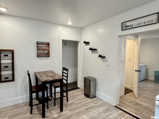 dining room with light hardwood / wood-style flooring and washer and clothes dryer