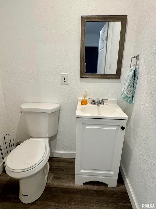 bathroom featuring vanity, toilet, and hardwood / wood-style flooring