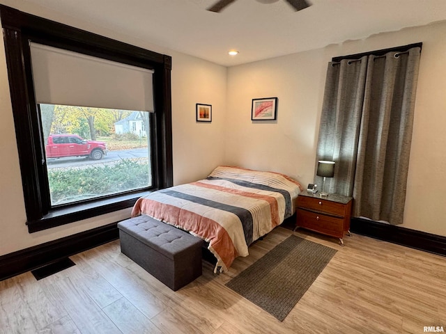 bedroom with light hardwood / wood-style floors and ceiling fan