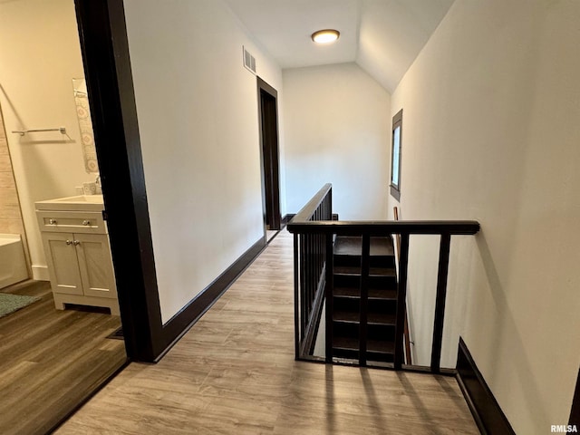 corridor featuring lofted ceiling and light wood-type flooring