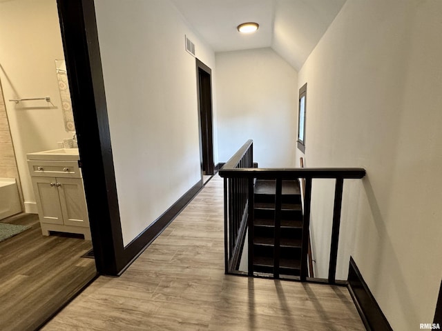 631 S Mcarthur St, Macomb, IL 61455 - corridor with an upstairs landing, vaulted ceiling, light wood-style flooring, and baseboards