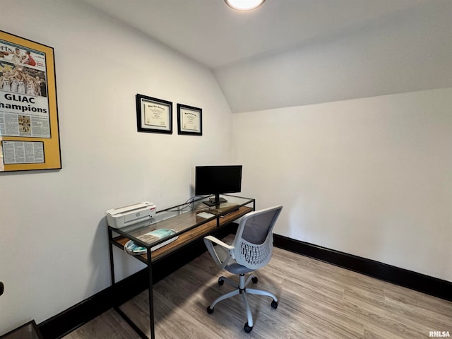 home office with vaulted ceiling and light hardwood / wood-style floors