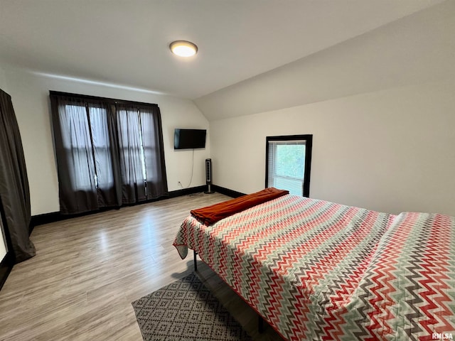 bedroom featuring vaulted ceiling and light wood-type flooring