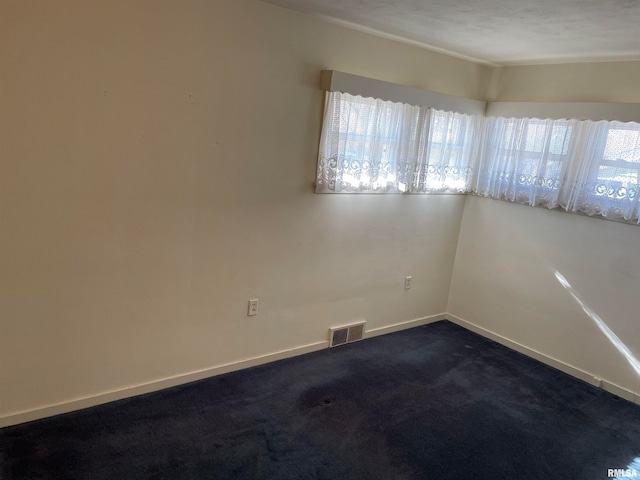 carpeted spare room featuring a textured ceiling