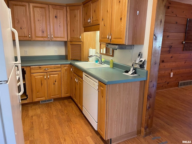 kitchen with white appliances, sink, and hardwood / wood-style floors