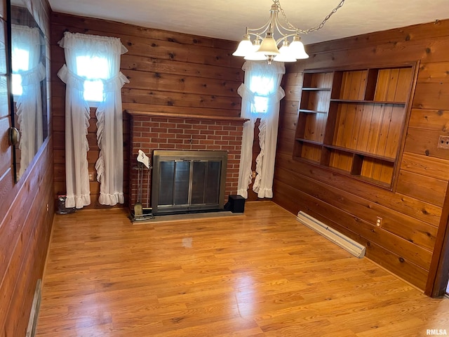 unfurnished living room featuring light hardwood / wood-style flooring, a wealth of natural light, and baseboard heating