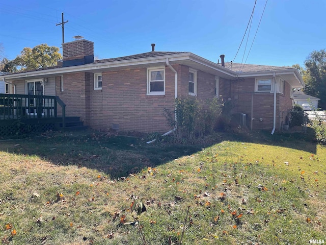 rear view of house with a yard and a deck