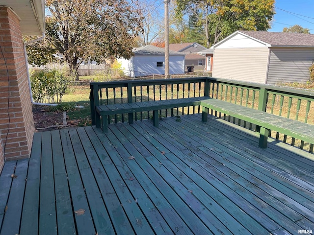 wooden terrace featuring a lawn