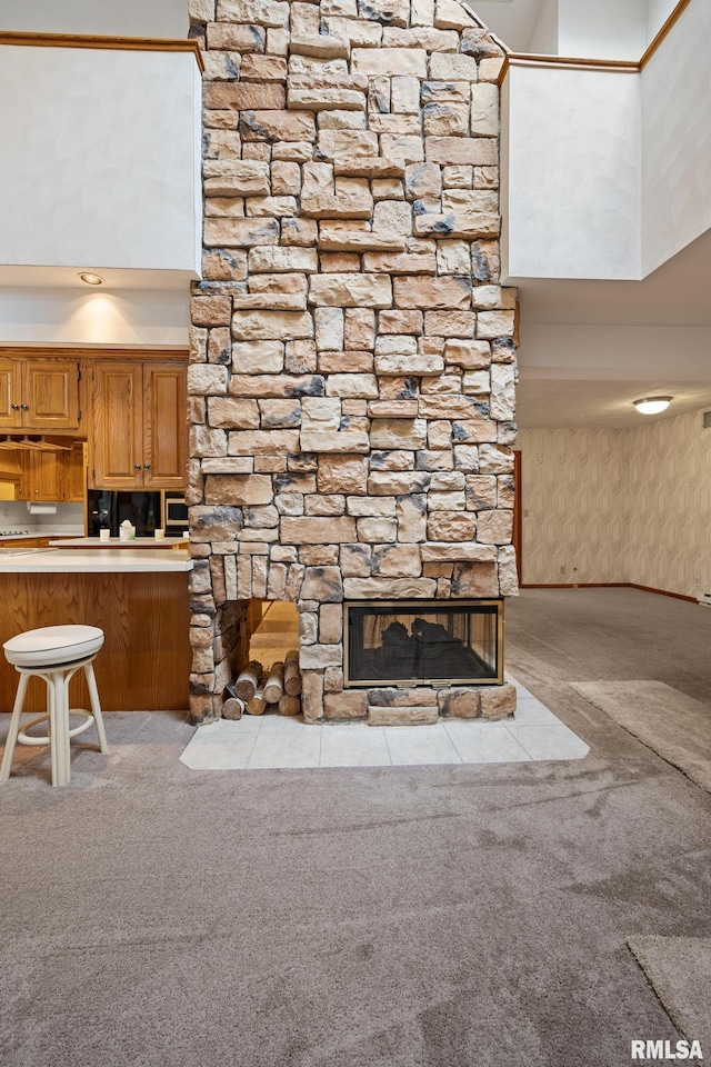 unfurnished living room with a high ceiling, light carpet, and a fireplace