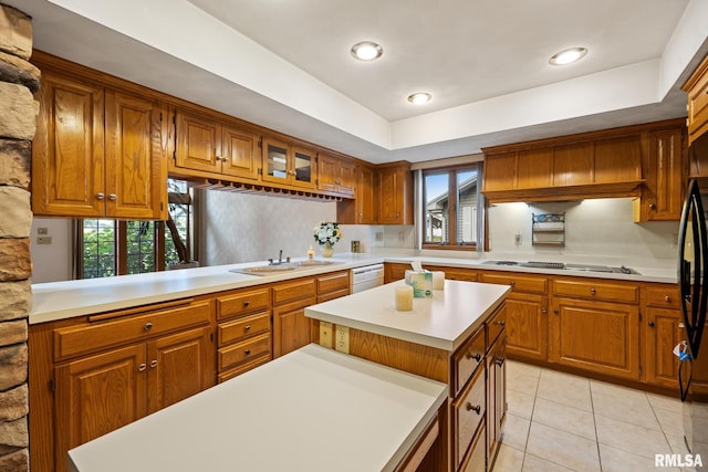 kitchen with white appliances, sink, a kitchen island, decorative backsplash, and light tile patterned floors