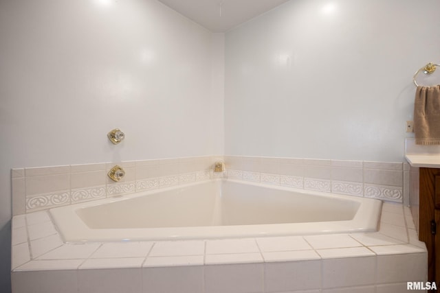 bathroom featuring vanity and tiled tub