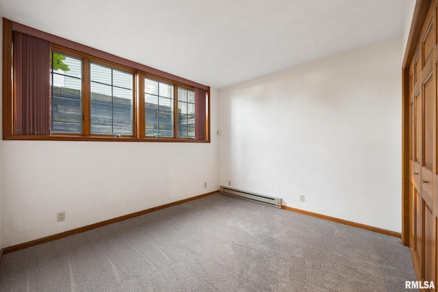 spare room with baseboard heating and carpet